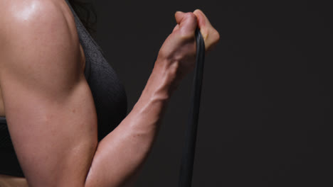 Close-Up-Studio-Shot-Of-Mature-Woman-Wearing-Gym-Fitness-Clothing-Exercising-With-Resistance-Band-1